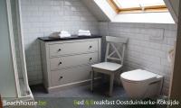 badkamer met toilet en opbergkast wastafel en stortbad