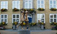 bronzen beeld van 2 spelende kinderen voor het oude gemeenthuis in oostduinkerke dorp