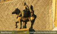 detail oud gemeentehuis oostduinerke, beeld in blauwsteen van een paardenvisser